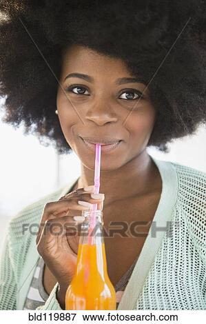 Stock Photo - Mixed race woman drinking soda. Fotosearch