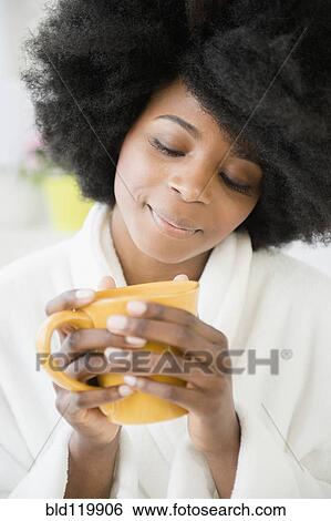 Stock Photograph - Mixed race woman enjoying cup of coffee. Fotosearch