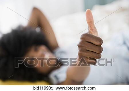 Stock Photography - Mixed race woman giving thumbs up. Fotosearch