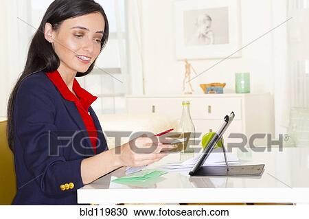 Stock Image - Mixed race woman online banking. Fotosearch