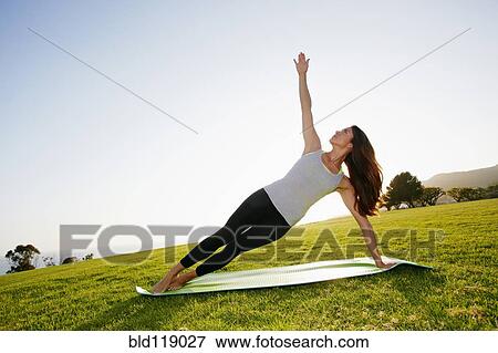 Mixed race woman practicing yoga in park View Large Photo Image Stock Photo - Mixed race woman practicing yoga in park. Fotosearch