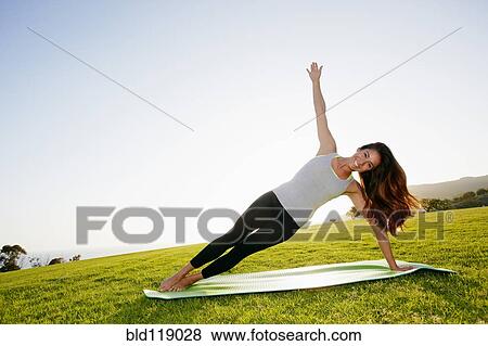 Mixed race woman practicing yoga in park View Large Photo Image Stock Photo - Mixed race woman practicing yoga in park. Fotosearch