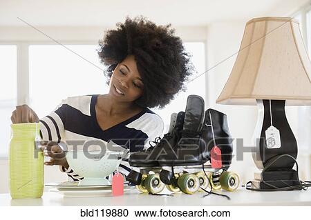 Mixed race woman putting price tag on items View Large Photo Image Stock Image - Mixed race woman putting price tag on items. Fotosearch