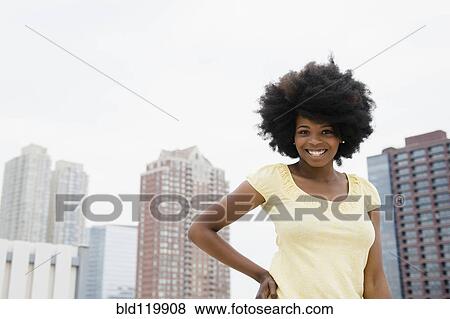 Mixed race woman smiling on urban rooftop View Large Photo Image Stock Photo - Mixed race woman smiling on urban rooftop. Fotosearch
