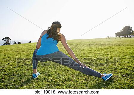 Mixed race woman stretching in park View Large Photo Image Stock Photo - Mixed race woman stretching in park. Fotosearch