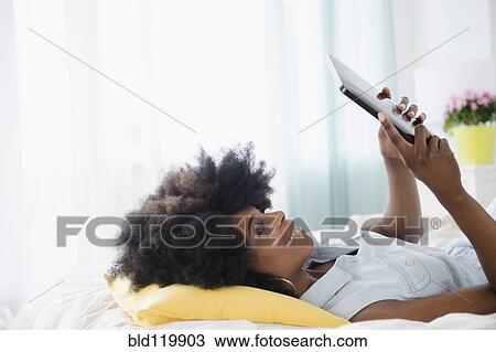 Stock Image - Mixed race woman using digital tablet. Fotosearch