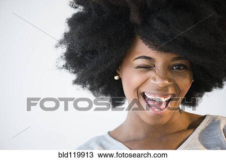 Stock Image - Mixed race woman winking. Fotosearch