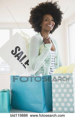 Stock Photograph - Mixed race woman with shopping bags. Fotosearch