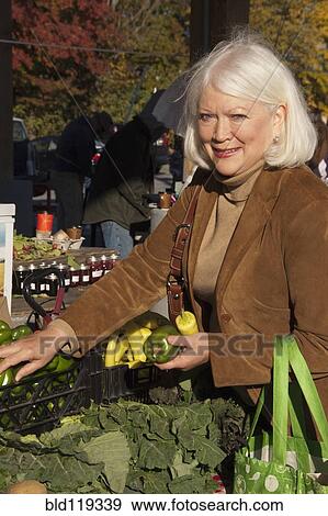 Stock Photo - Older Caucasian woman shopping at farmer's market. Fotosearch
