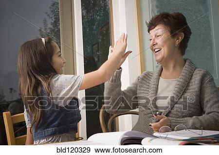 Older Hispanic woman high-fiving granddaughter View Large Photo Image Stock Photo - Older Hispanic woman high-fiving granddaughter. Fotosearch