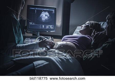 Stock Photography - Pregnant couple having sonogram. Fotosearch