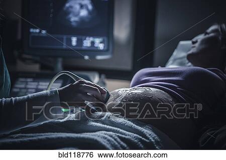 Stock Photograph - Pregnant woman having sonogram. Fotosearch