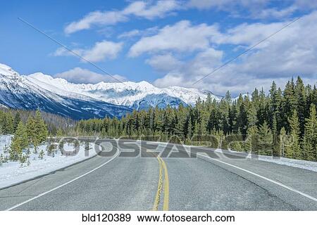 Stock Photo - Road leading to snowy mountains. Fotosearch