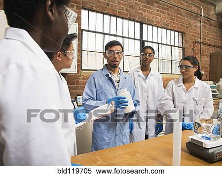 Stock Photography - Students listening to teacher in science lab. Fotosearch