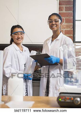Stock Image - Students smiling in science lab. Fotosearch
