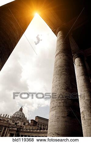 Stock Photo - Sun rising over columned buildings. Fotosearch
