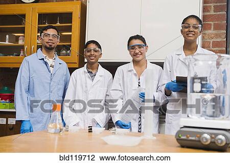Stock Image - Teacher and students smiling in science lab. Fotosearch