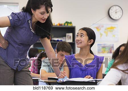 Stock Photo - Teacher helping student in class. Fotosearch