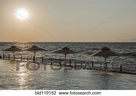 Stock Image - Umbrellas along shoreline, Rhodes, Greece. Fotosearch