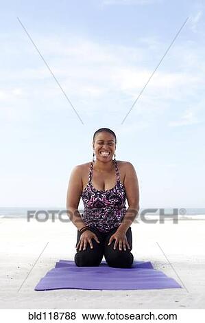 Stock Photo - Woman practicing yoga on beach. Fotosearch