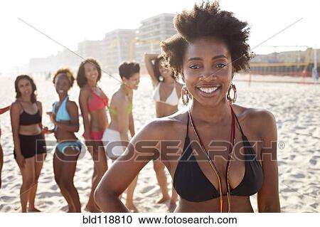 Stock Image - Women smiling together on beach. Fotosearch