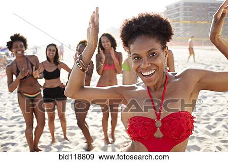 Stock Photo - Women smiling together on beach. Fotosearch