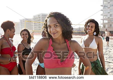 Stock Photograph - Women smiling together on beach. Fotosearch