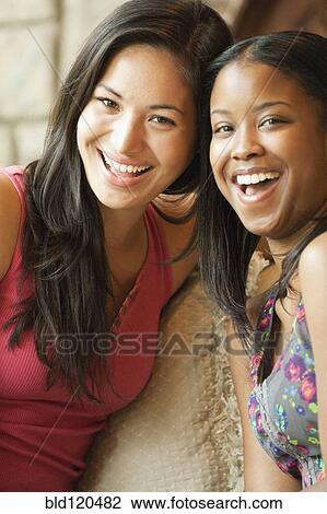 Women smiling together on sofa View Large Photo Image Stock Image - Women smiling together on sofa. Fotosearch