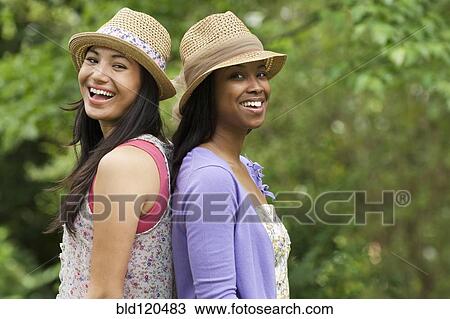 Women standing back to back outdoors View Large Photo Image Stock Image - Women standing back to back outdoors. Fotosearch
