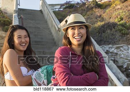 Stock Photo - Women standing by steps on beach. Fotosearch