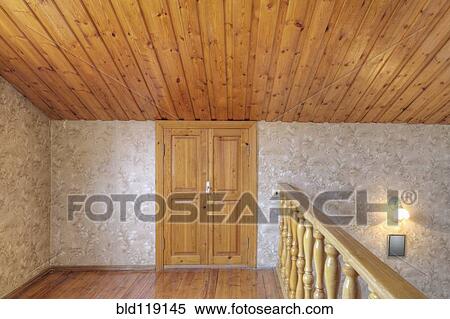 Stock Photography - Wooden door and banister with slanted ceiling. Fotosearch
