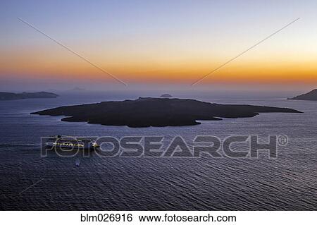 Stock Photograph - Aerial view of cruise ship sailing in ocean at sunset, Santorini, Greece. Fotosearch