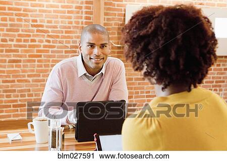 Stock Image - African American business people working in cafe. Fotosearch