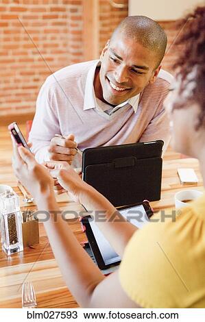 Stock Image - African American business people working in cafe. Fotosearch