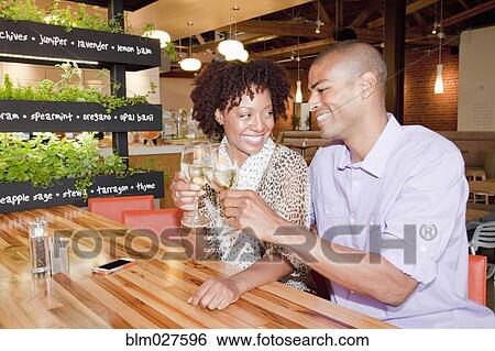 Stock Photograph - African American couple toasting each other at bar. Fotosearch