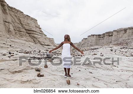 Picture - African American woman standing in rock formations, Santa Fe, New Mexico, United States. Fotosearch