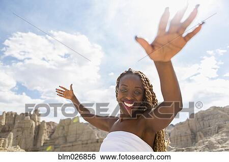 Stock Photograph - African American woman standing in rock formations, Santa Fe, New Mexico, United States. Fotosearch