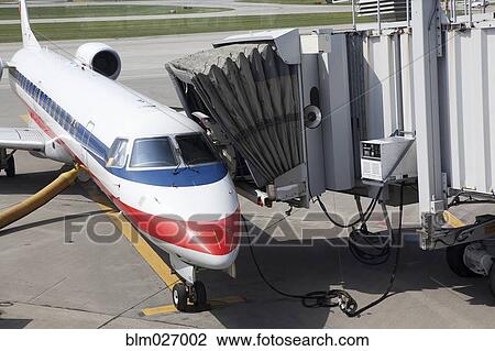Airplane and passenger boarding bridge on runway View Large Photo Image Stock Image - Airplane and passenger boarding bridge on runway. Fotosearch