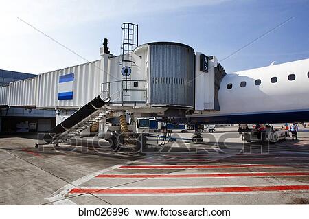 Airplane and passenger boarding bridge on runway View Large Photo Image Stock Photograph - Airplane and passenger boarding bridge on runway. Fotosearch