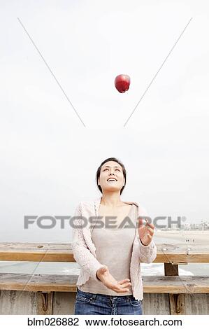 Asian woman throwing red apple View Large Photo Image Stock Image - Asian woman throwing red apple. Fotosearch