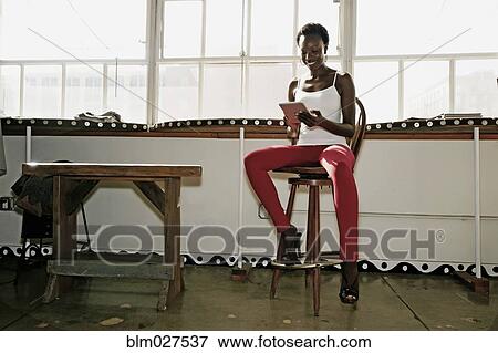 Stock Photo - Black woman using digital tablet. Fotosearch