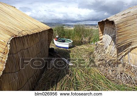 Stock Photograph - Boat mooring between straw huts. Fotosearch