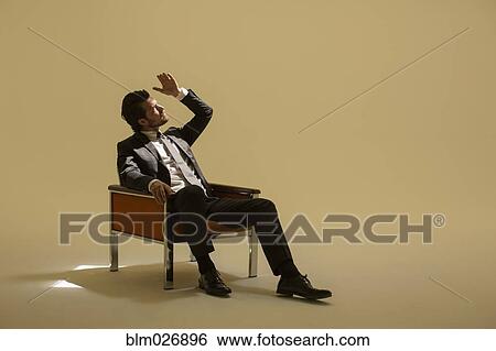 Caucasian businessman sitting under spotlight View Large Photo Image Stock Photograph - Caucasian businessman sitting under spotlight. Fotosearch