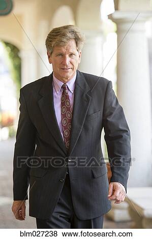 Caucasian businessman walking in colonnade View Large Photo Image Stock Photo - Caucasian businessman walking in colonnade. Fotosearch