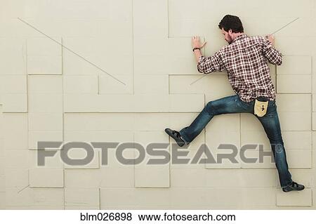 Caucasian climber scaling geometric wall View Large Photo Image Stock Photo - Caucasian climber scaling geometric wall. Fotosearch
