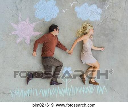 Stock Photo - Caucasian couple posing over sidewalk chalk drawing. Fotosearch