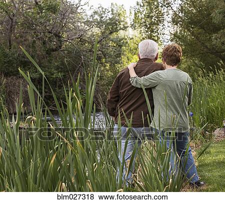 Caucasian couple relaxing by river View Large Photo Image Stock Photo - Caucasian couple relaxing by river. Fotosearch