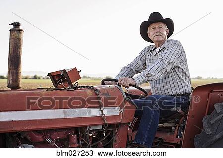 Caucasian farmer driving tractor View Large Photo Image Stock Image - Caucasian farmer driving tractor. Fotosearch