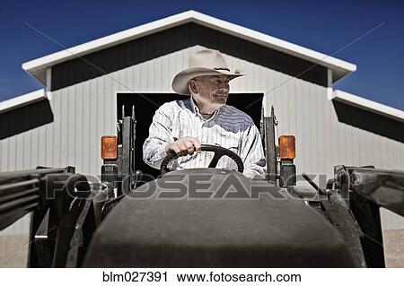 Caucasian farmer driving tractor View Large Photo Image Stock Image - Caucasian farmer driving tractor. Fotosearch