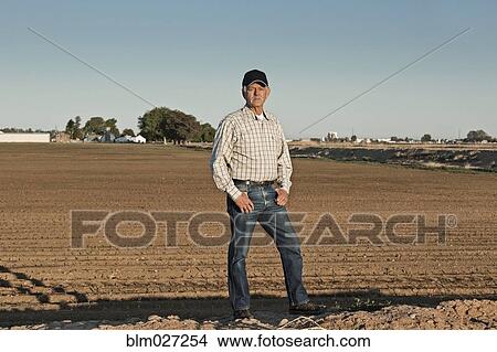 Caucasian farmer standing in irrigated field View Large Photo Image Picture - Caucasian farmer standing in irrigated field. Fotosearch